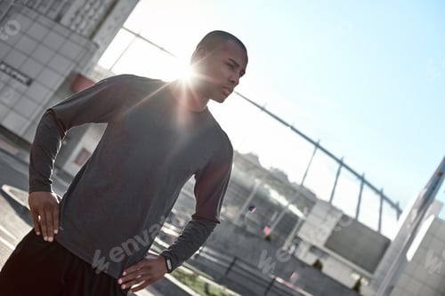 Preview: Urban sports. Young man is doing warming up before running in the city on a morning