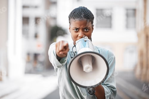 Preview: Shot of a young woman screaming into a loud speaker while protesting in the city