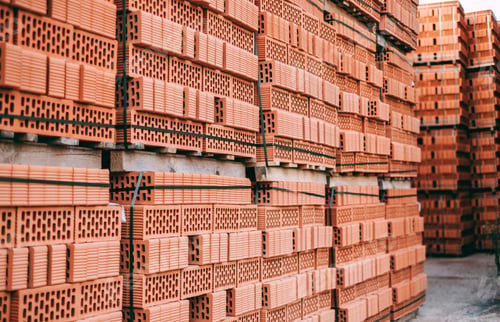 Preview: Stacks of orange clay brick on pallet. Brick production concept