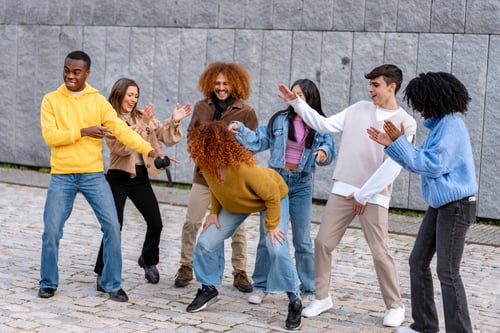 Preview: Multiethnic friends having fun while dancing outdoors.
