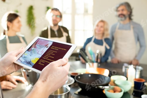 Preview: Hands of male cooking coach with tablet looking through online recipes