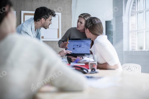 Preview: Design team brainstorming at boardroom table in design studio