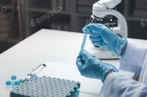 Preview: Lab assistant, medical scientist, chemistry researcher holds a glass tube through a chemical test tu