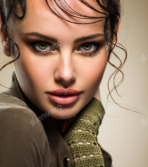 Preview: Closeup portrait of a beautiful young fashion woman with glamour makeup posing at studio.