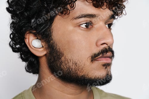 Preview: Young middle eastern man listening music with earphones