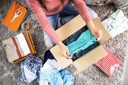 Preview: Woman putting her clothes in a delivery box