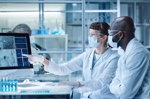 Preview: Woman in mask pointing at computer monitor and examining the views of bacterium together with her