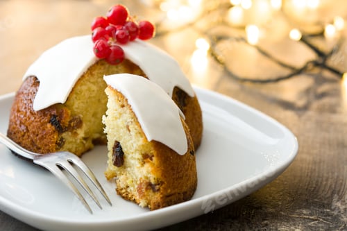 Preview: Christmas pudding with icing and redcurrants on a white plate