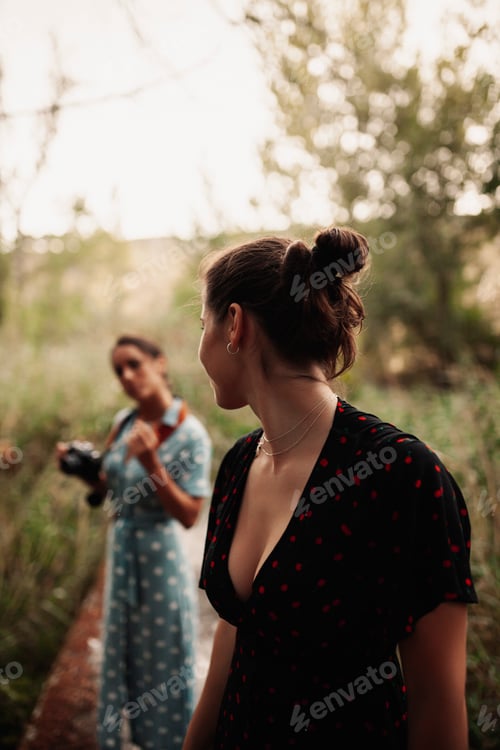 Preview: Two young women taking photos each other in the forest