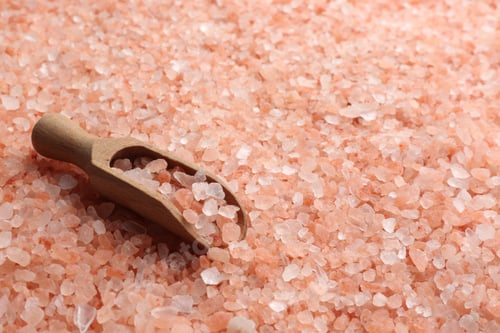 Preview: Pink himalayan salt and wooden scoop as background, closeup