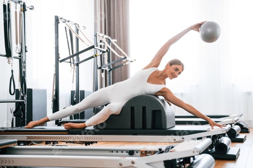 Preview: Using fitness ball. Young woman is doing exercises