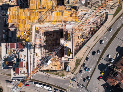 Preview: Construction site showcases vibrant materials and equipment under bright sunlight in an urban area