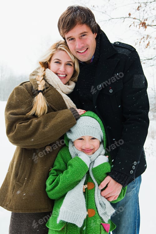Preview: Family Smiling in Winter Snow Wearing Warm Clothes