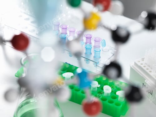 Preview: View through molecular model onto eppendorf tubes which are being used to test a sample in the