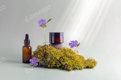 Preview: cosmetics containers standing on moss next to periwinkle flowers
