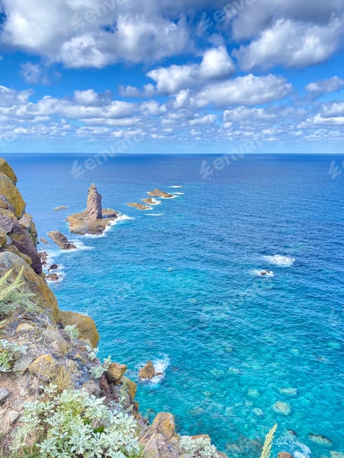 Preview: Scenic rocky coastline under a blue sky.