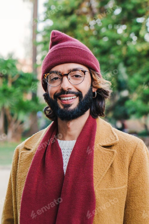 Preview: Vertical individual portrait of young adult man with goggles and beard, smiling and looking at