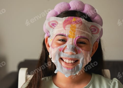 Preview: Female kid using beauty face mask for skincare - Treatment, social media trend and childhood concept