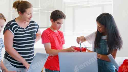 Preview: Group Of Students With Female Teacher In School Computer Coding Class Learn To Program Robot Vehicle
