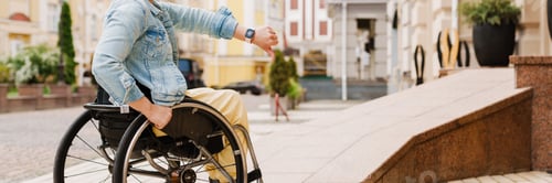 Preview: Brunette woman gesturing while sitting in wheelchair by ramp