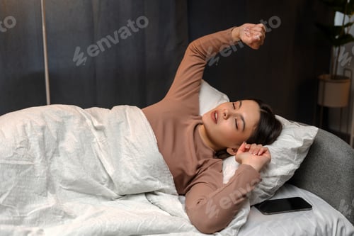 Preview: Young girl, teenager waking up and stretching in bed after sleep