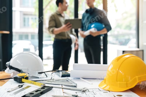 Preview: Engineer teams meeting working together holding worker helmets on construction site in modern city