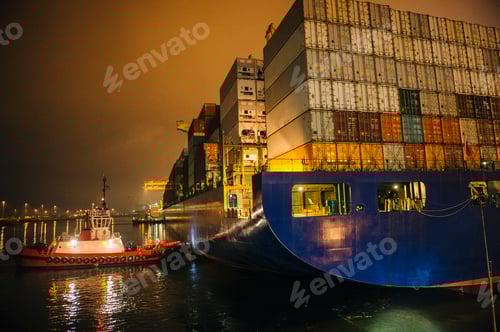 Preview: Tugboat manoeuvring container ship on river at night, Tacoma, Washington, USA