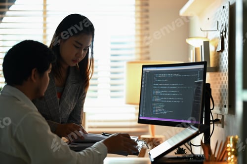 Preview: Team of software developers working with coded data on computer screen at dark room