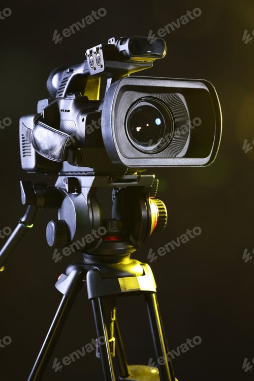 Preview: Modern video camera with tripod on black background, closeup