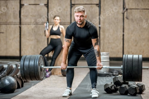Preview: Man lifting up a burbell in the gym