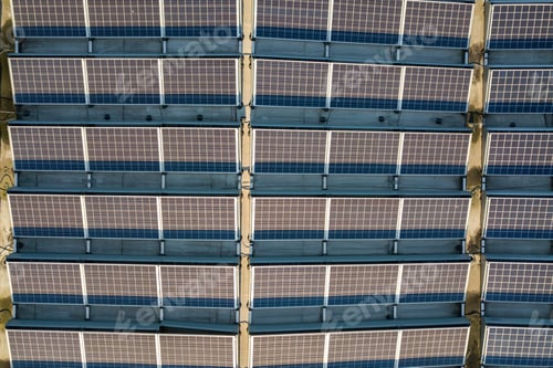 Preview: Aerial view of many photo voltaic solar panels mounted of industrial building roof.