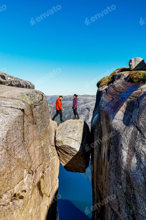 Preview: Adventurers Balancing on Boulders in Norways Majestic Fjord Landscape, Kjerag Kjeragbolten