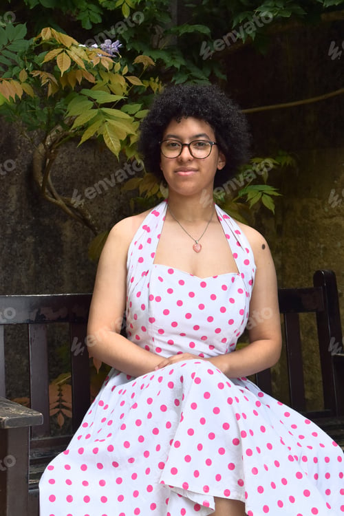 Preview: beautiful mixed race young woman with afro hair, glasses and summer dress