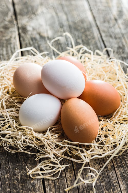 Preview: Whole chicken eggs on wooden table.