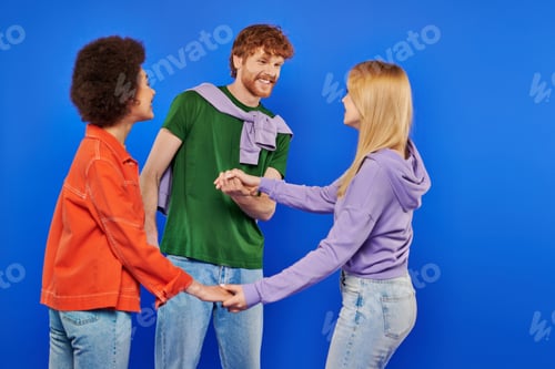 Preview: polyamorous relationship concept, polygamy lovers, young man and multicultural women holding hands
