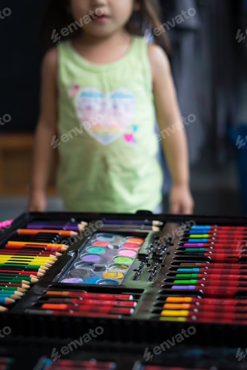 Preview: colourful pencils in stationeries set and toddler in the background