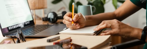Preview: African american young woman using laptop and taking notes at home