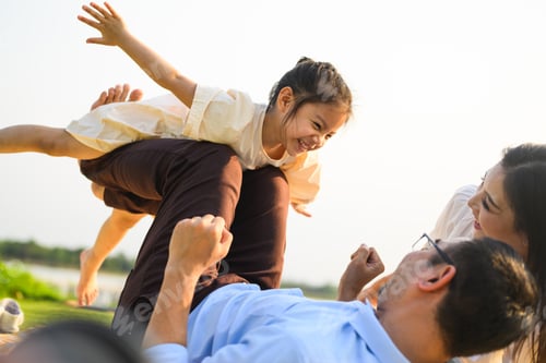 Preview: Happy family relaxing and resting in park together on weekend
