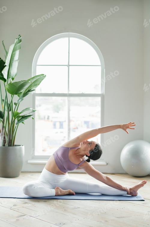 Preview: Fitness woman in a Parivrtta Janu Sirsasana pose