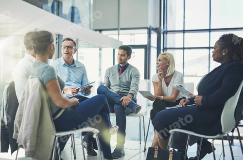 Preview: Shot of a group of coworkers talking together while sitting in a circle in an office