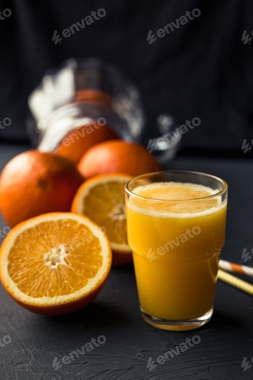 Preview: Fresh orange juice and fresh fruit oranges on a black background