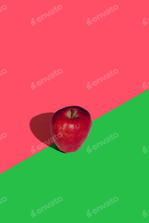 Preview: Close-up shot of a single apple, resting on a vibrant green and red background