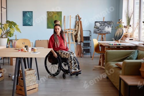 Preview: Young Woman with Disability Sitting in Wheelchair in Art Studio