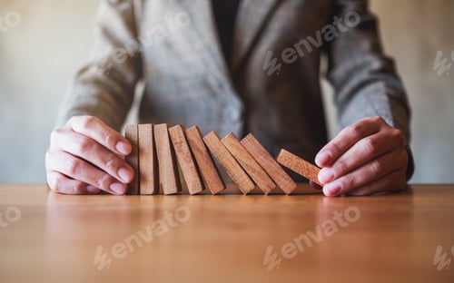 Preview: Closeup image of a businessman try to holding wooden block while falling for business concept