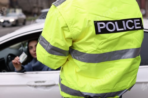 Preview: Woman giving bribe to police officer out of car window, closeup