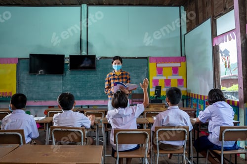 Preview: Asian children student wear face mask learning in classroom at elementary school.