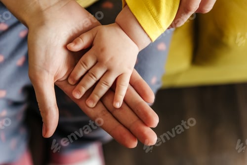 Preview: Close up of Baby touching mother's hand.