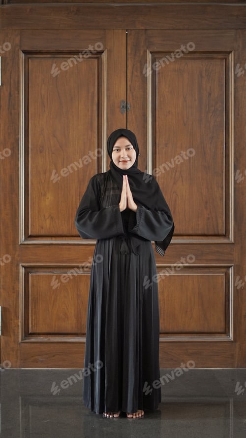 Preview: woman in black Muslim dress gesturing sorry in mosque