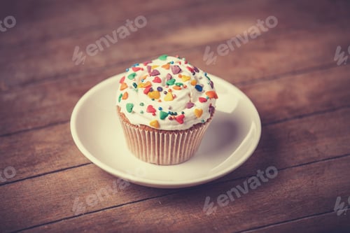 Preview: Cream cake with plate on a wooden table.