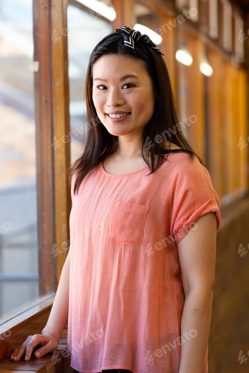 Preview: Portrait of happy asian female teacher in elementary school corridor